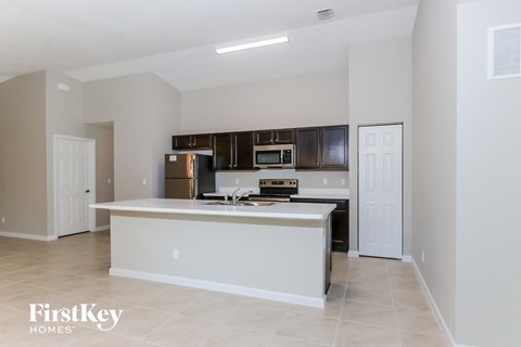 a kitchen with an island and a stove and a refrigerator