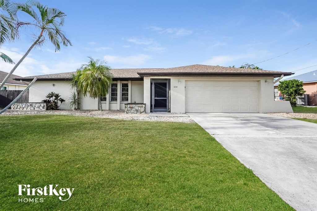 A house with a garage and a driveway in front of it.