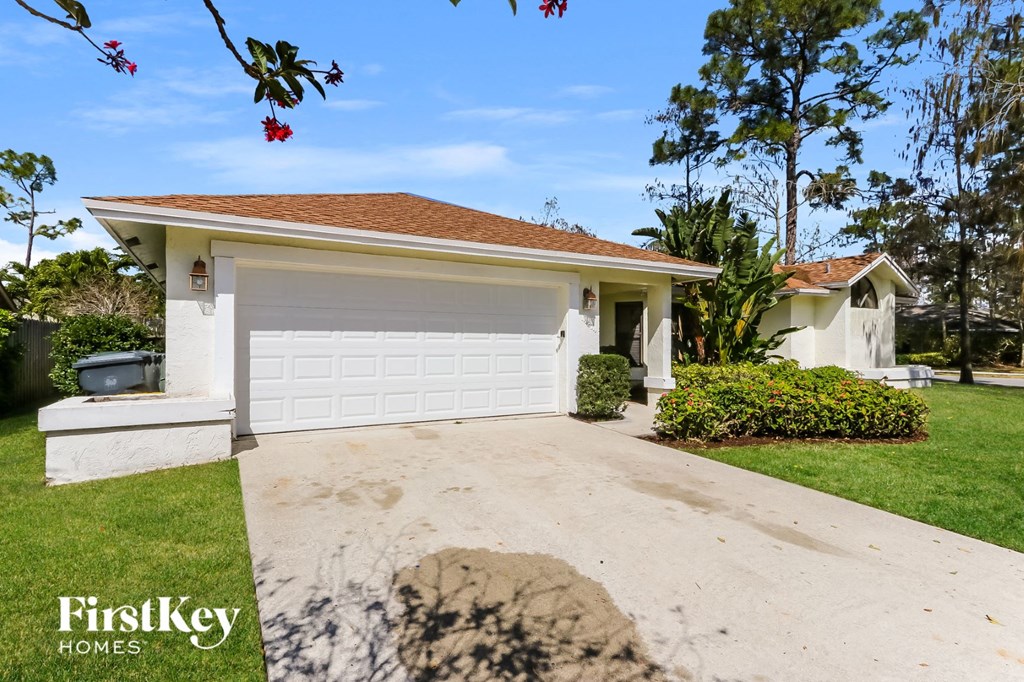 a white house with a white garage door and a driveway
