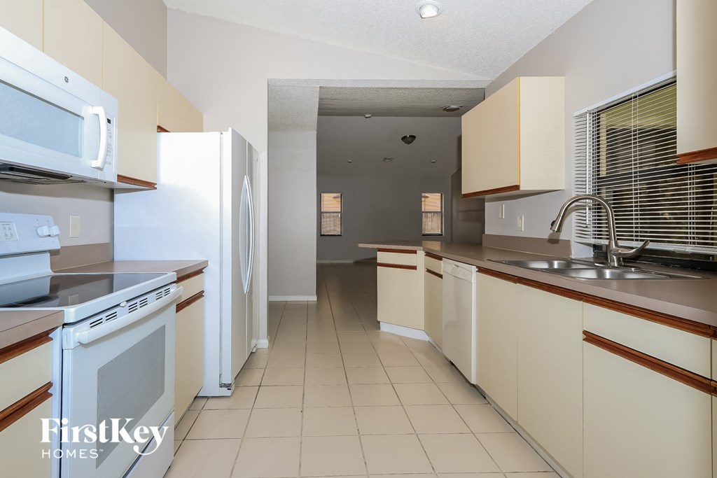 a kitchen with white cabinets and a sink and a refrigerator