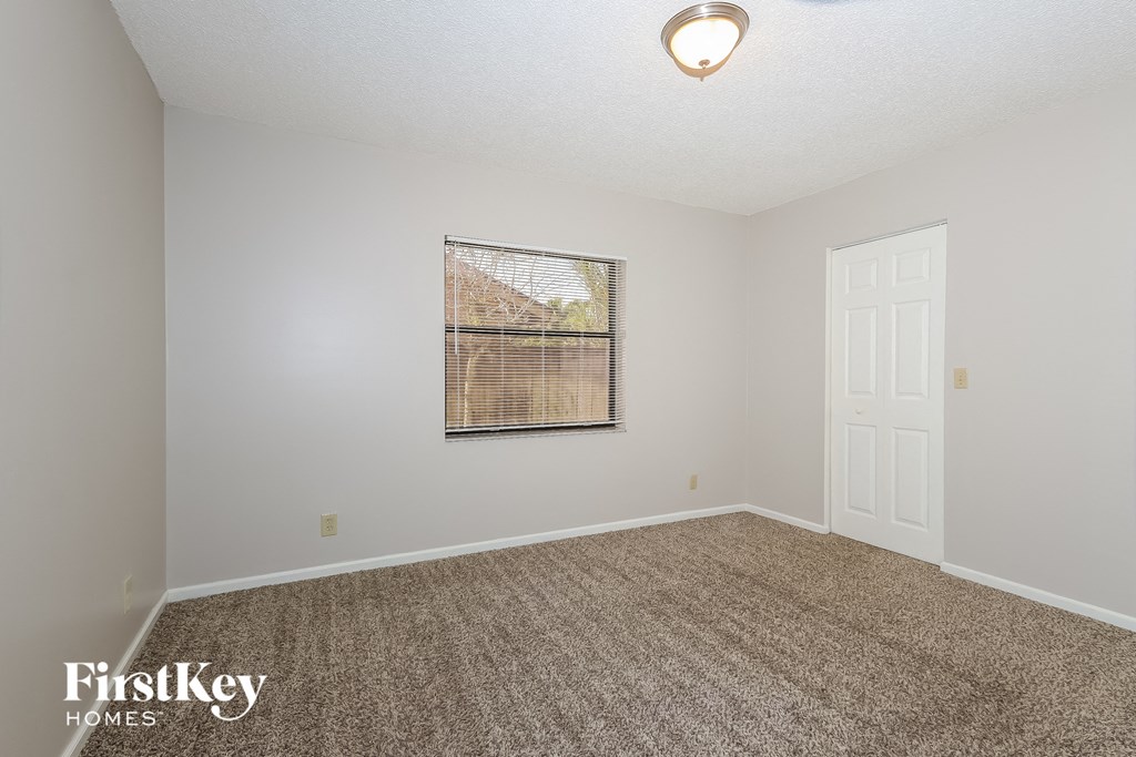 a spacious living room with carpet and a white door