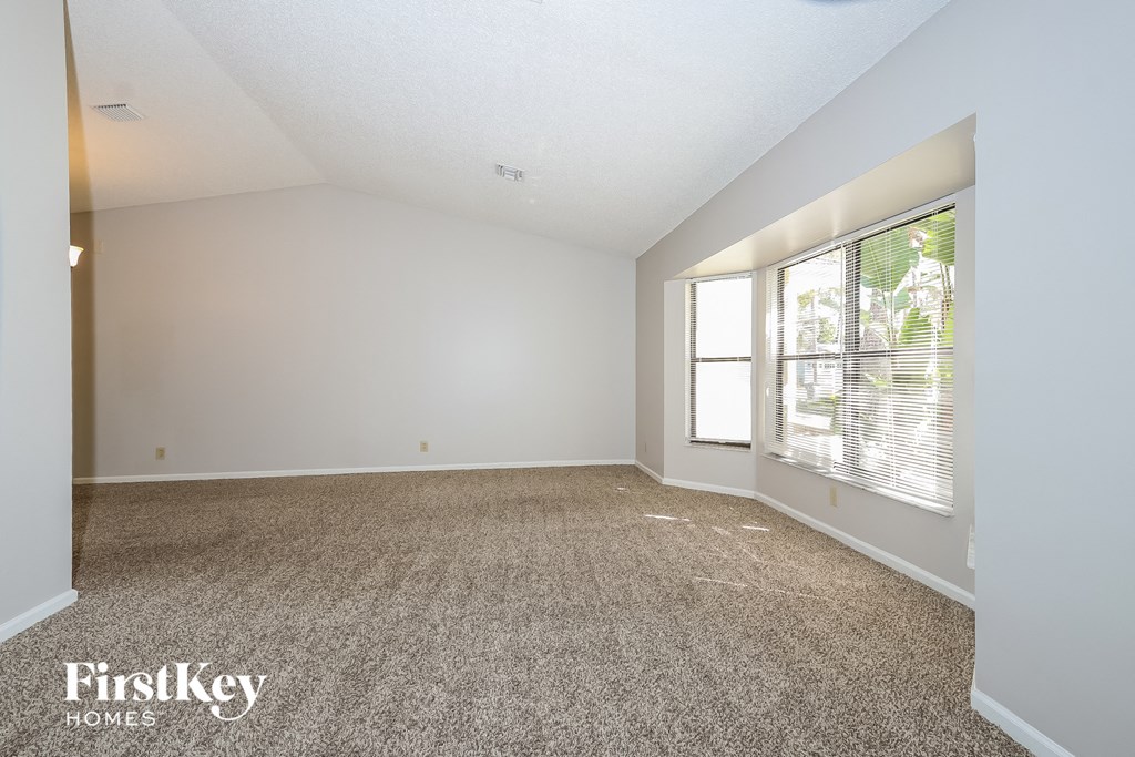 a spacious living room with carpet and a large window