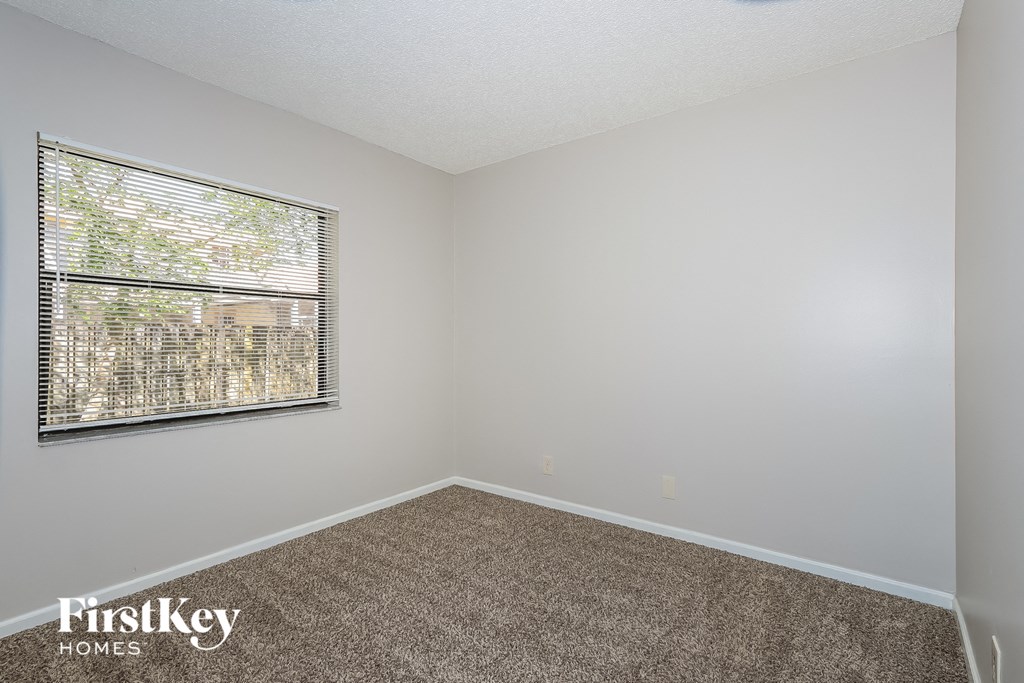 an empty room with a window and carpet