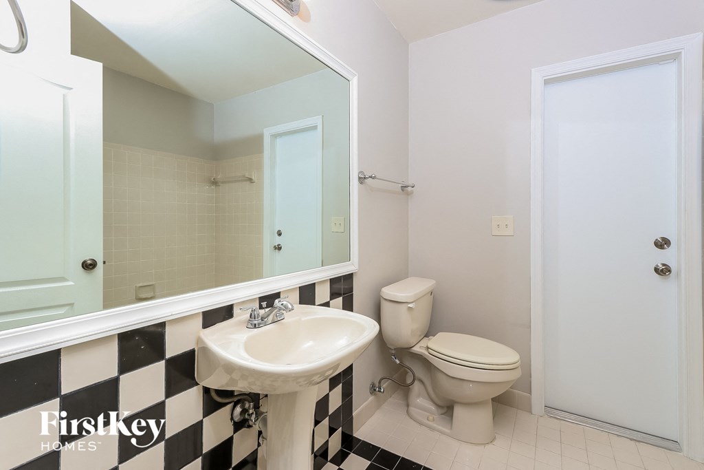 a bathroom with a toilet and a sink and a mirror