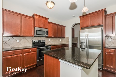 A kitchen with wooden cabinets and a black countertop.