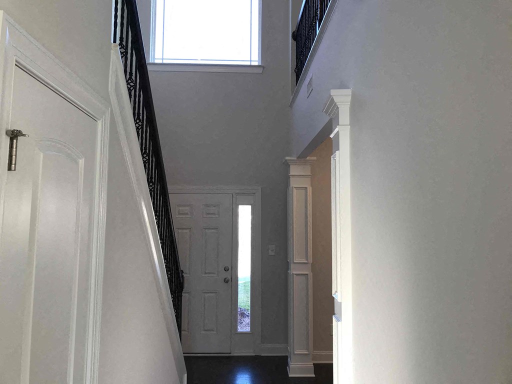 A white door is at the end of a hallway.