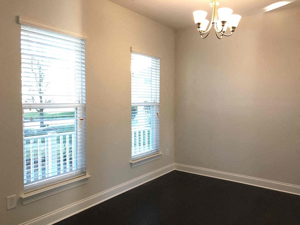 A room with two windows and a chandelier.