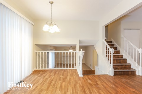 A large open living space with a staircase leading to the upper floor.
