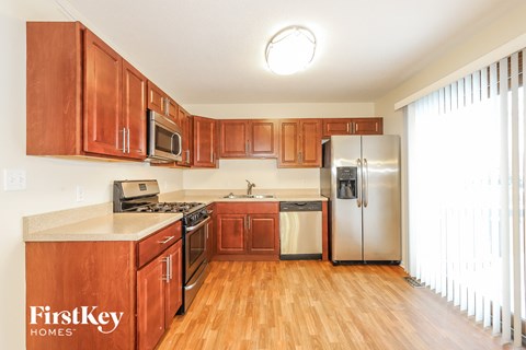 A kitchen with wooden cabinets and a refrigerator.