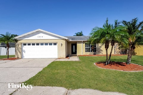 a yellow house with palm trees in front of it