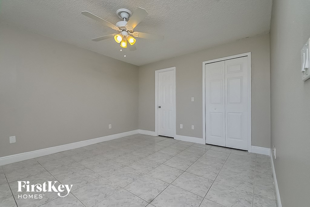the living room of an empty house with a ceiling fan