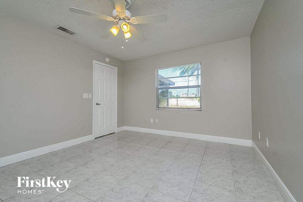 the living room of an empty house with a ceiling fan