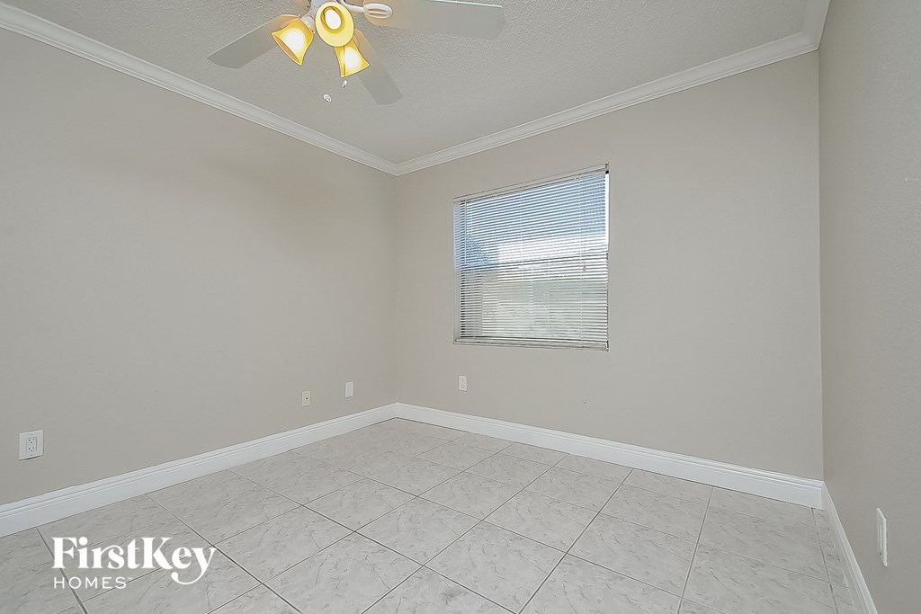 a empty living room with a ceiling fan and a window