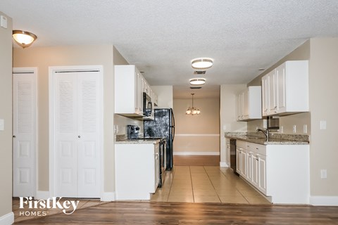 a kitchen with white cabinets and a black refrigerator