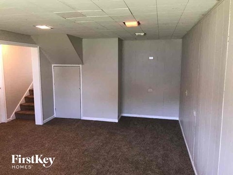 an empty basement with a carpeted floor and white walls