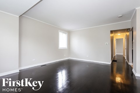 a empty living room with white walls and a black floor