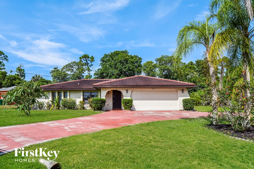 a house with a garage and a palm tree