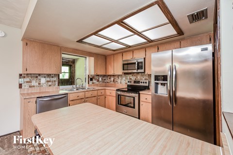 a kitchen with wooden cabinets and stainless steel appliances