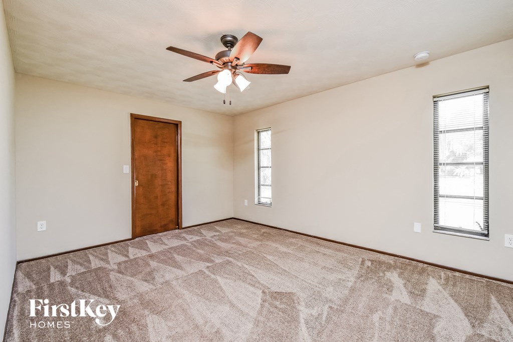 the living room is spacious and clean with a ceiling fan