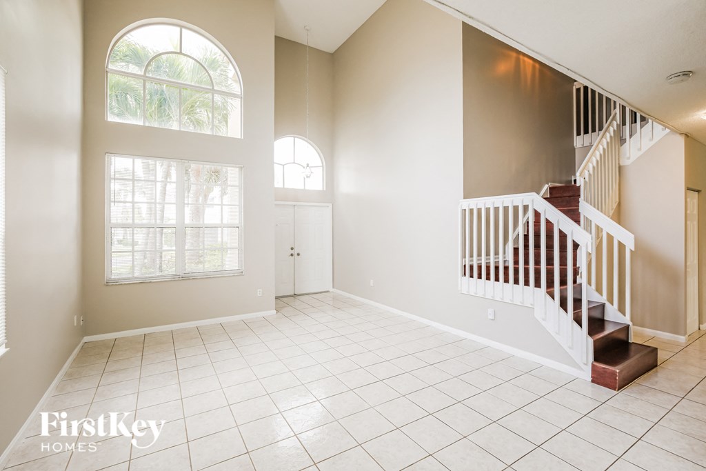A spacious room with a staircase and large windows.