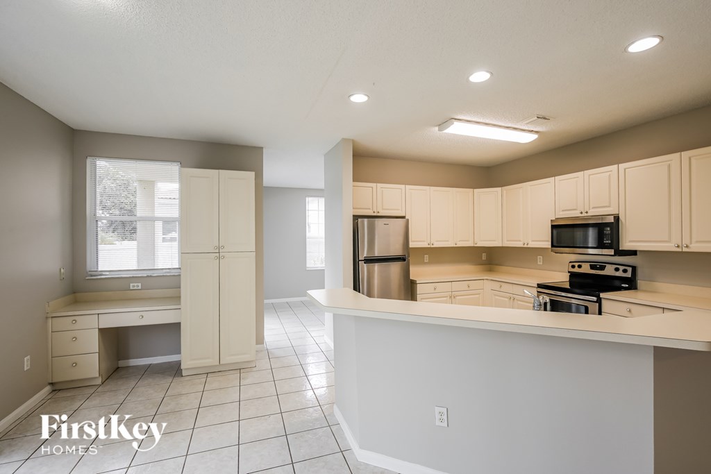 A kitchen with a desk and a window.