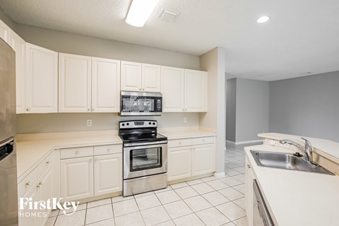 A kitchen with white cabinets and appliances is on the market.