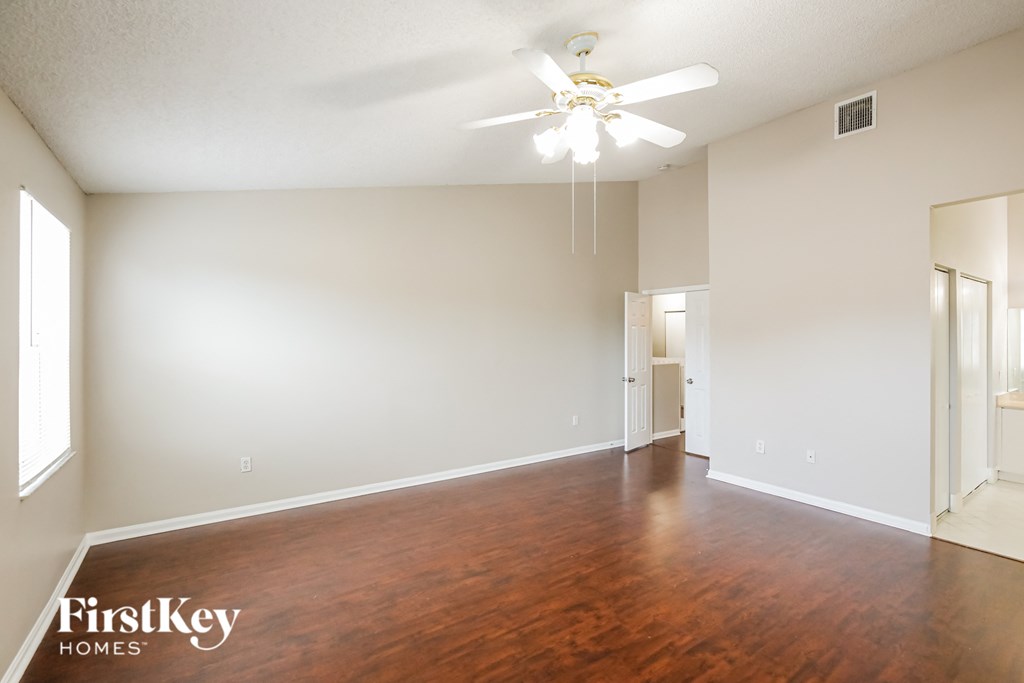 A room with wooden floors and a ceiling fan.