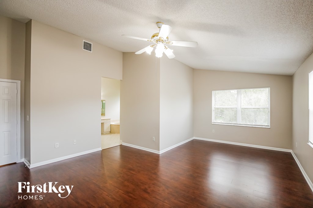 A room with wooden floors and a ceiling fan.