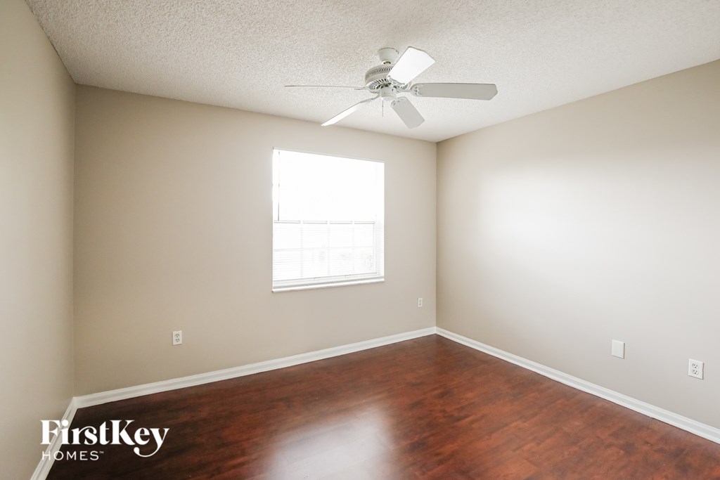 A room with a fan and a window.
