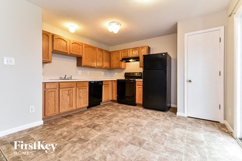 A kitchen with wooden cabinets and black appliances.