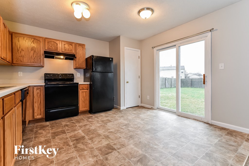 A kitchen with wooden cabinets and black appliances.