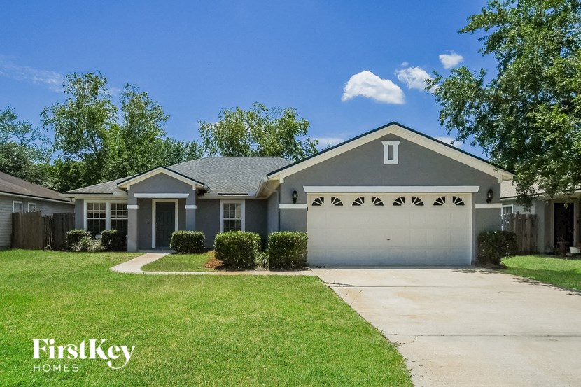 a blue house with a lawn and a white garage door