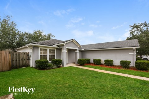 A house with a well-maintained lawn and a clear sky.