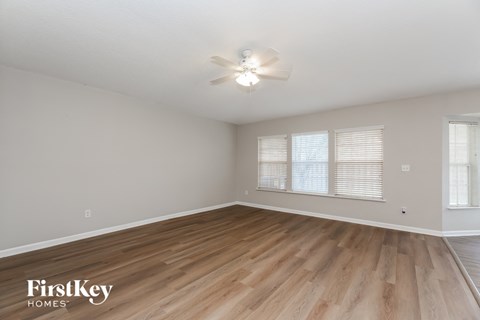A room with wooden flooring and a ceiling fan.