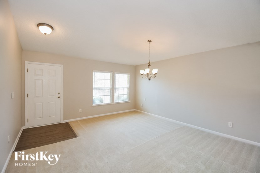 the living room and dining room in a home with a white door