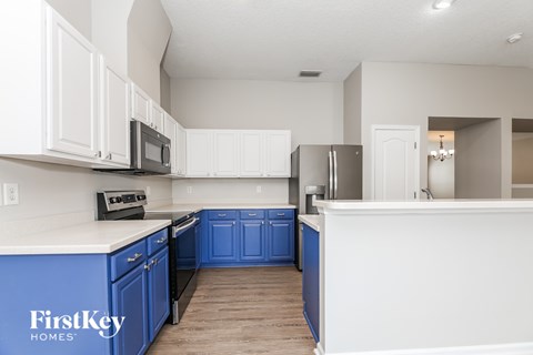 A kitchen with blue cabinets and white walls.