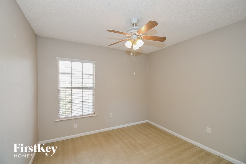 a bedroom with a ceiling fan and a window