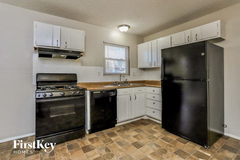 a kitchen with black appliances and white cabinets