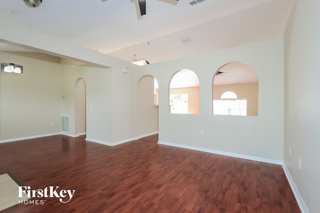 an empty living room with wood floors and white walls