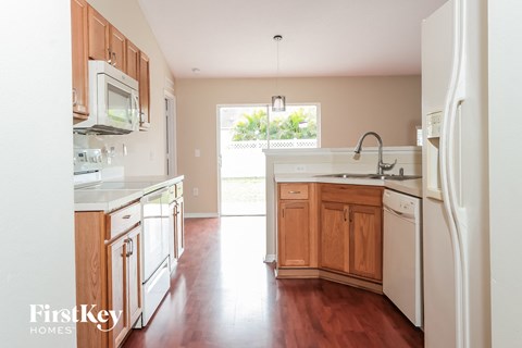 a kitchen with white appliances and wooden cabinets