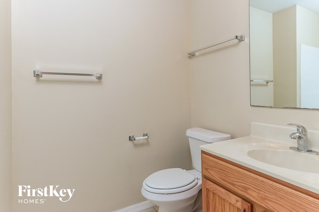 a bathroom with a toilet and a sink and a mirror