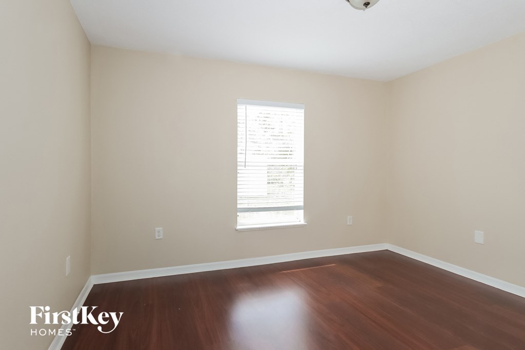 an empty room with wood floors and a window