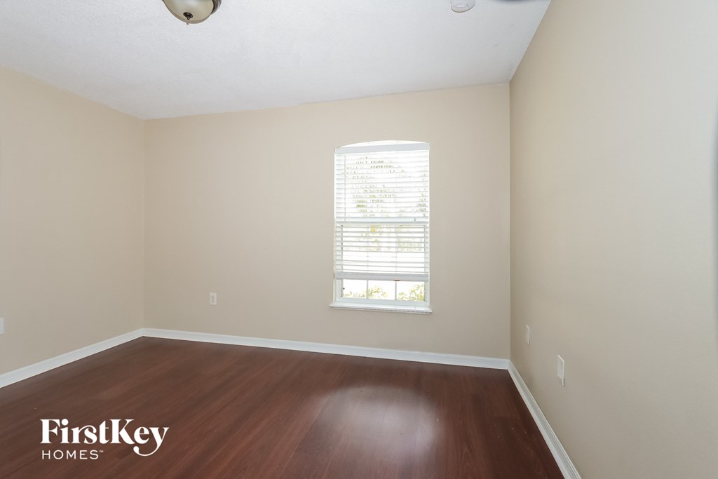 an empty room with wood floors and a window