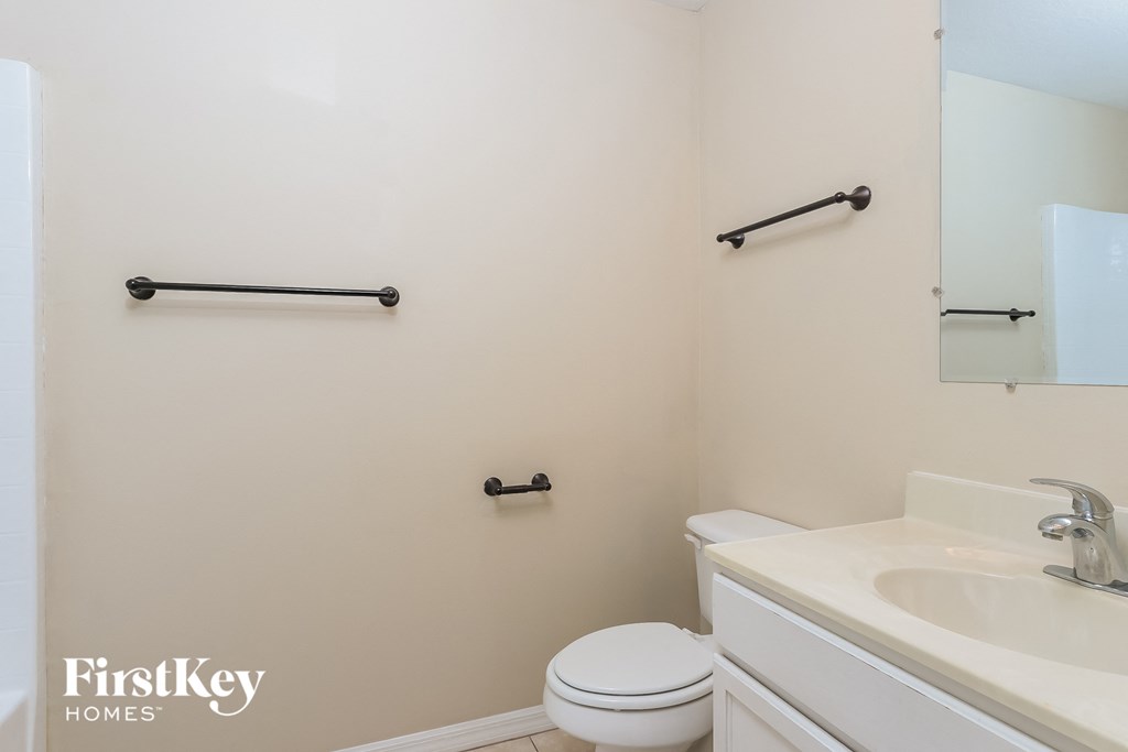 a bathroom with a sink toilet and a mirror