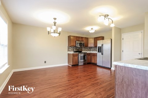 a kitchen and living room with wood flooring and stainless steel appliances