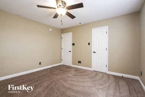 a living room with carpet and a ceiling fan