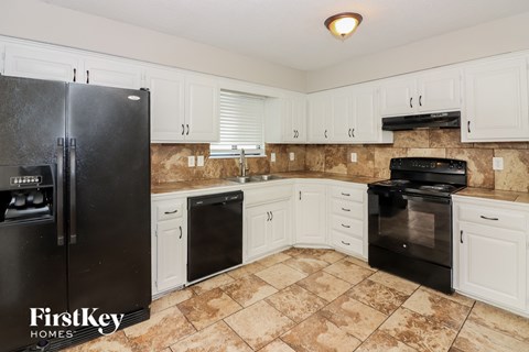 a kitchen with black appliances and white cabinets