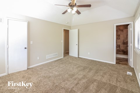 a living room with carpet and a ceiling fan