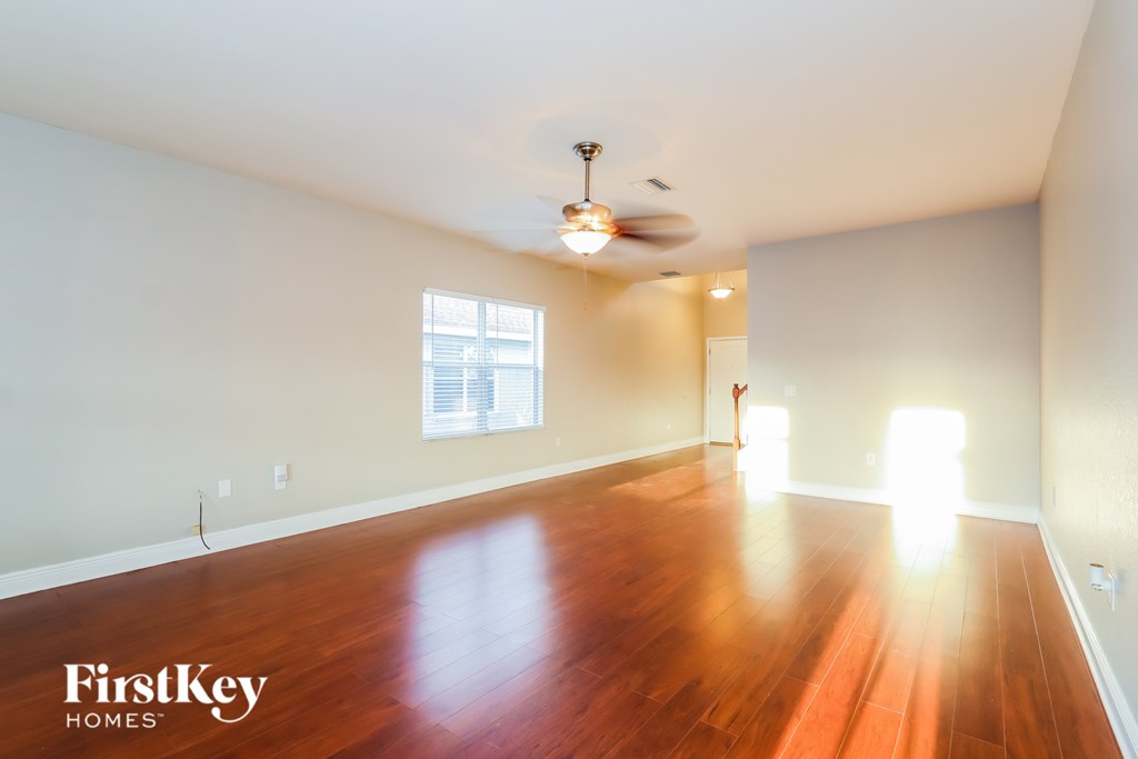 A room with wooden floors and a ceiling fan.