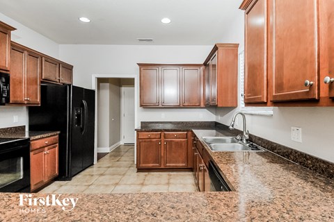 A kitchen with brown cabinets and black appliances.